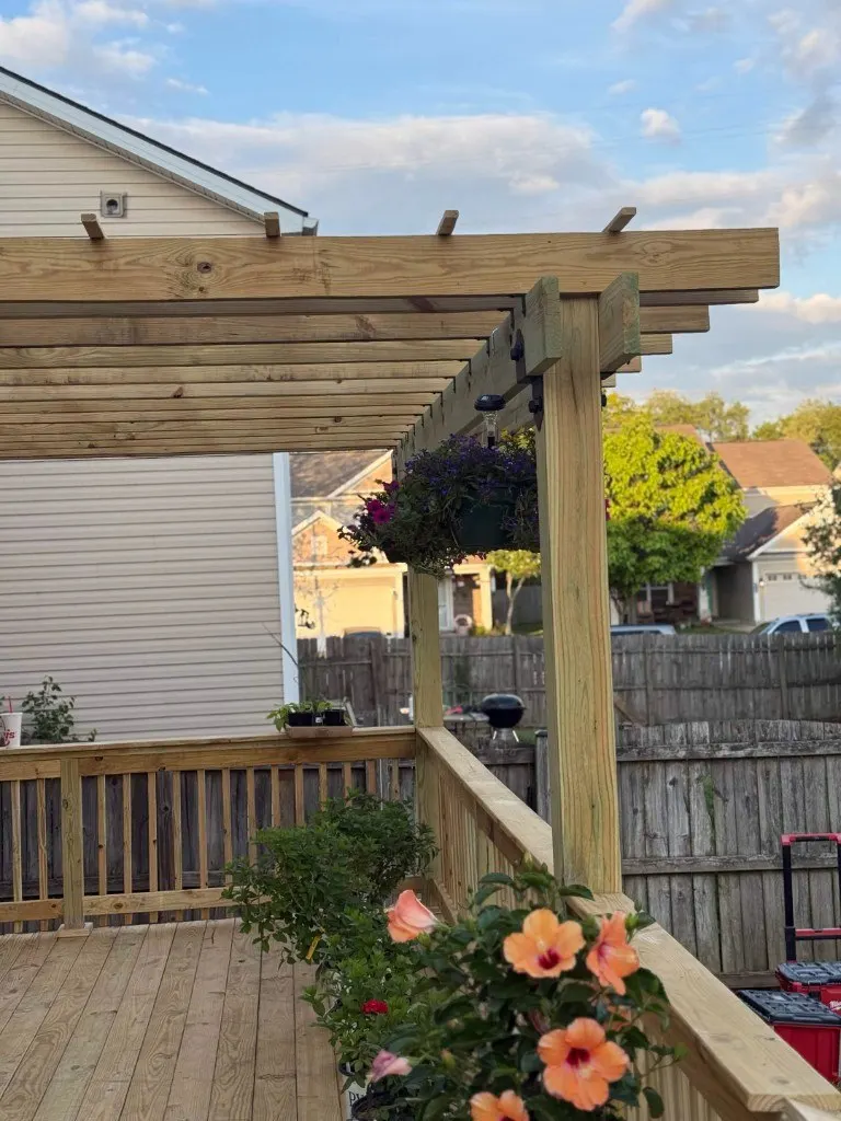 Custom pressure-treated pergola with hanging flower baskets over wood deck in Lexington KY by Big Blue Fence & Deck