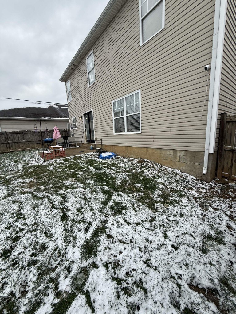 Before photo: side of home prior to outdoor living build by Big Blue Fence & Deck
